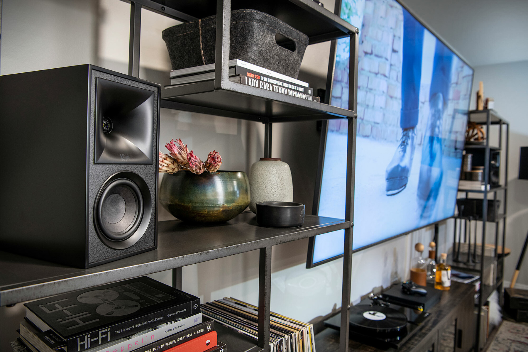 The Fives Powered Speaker Monitors next to TV