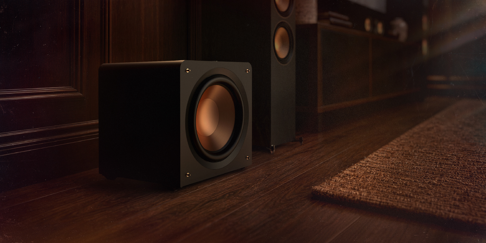 Klipsch Compact Subwoofer on floor beside media console and floor speakers