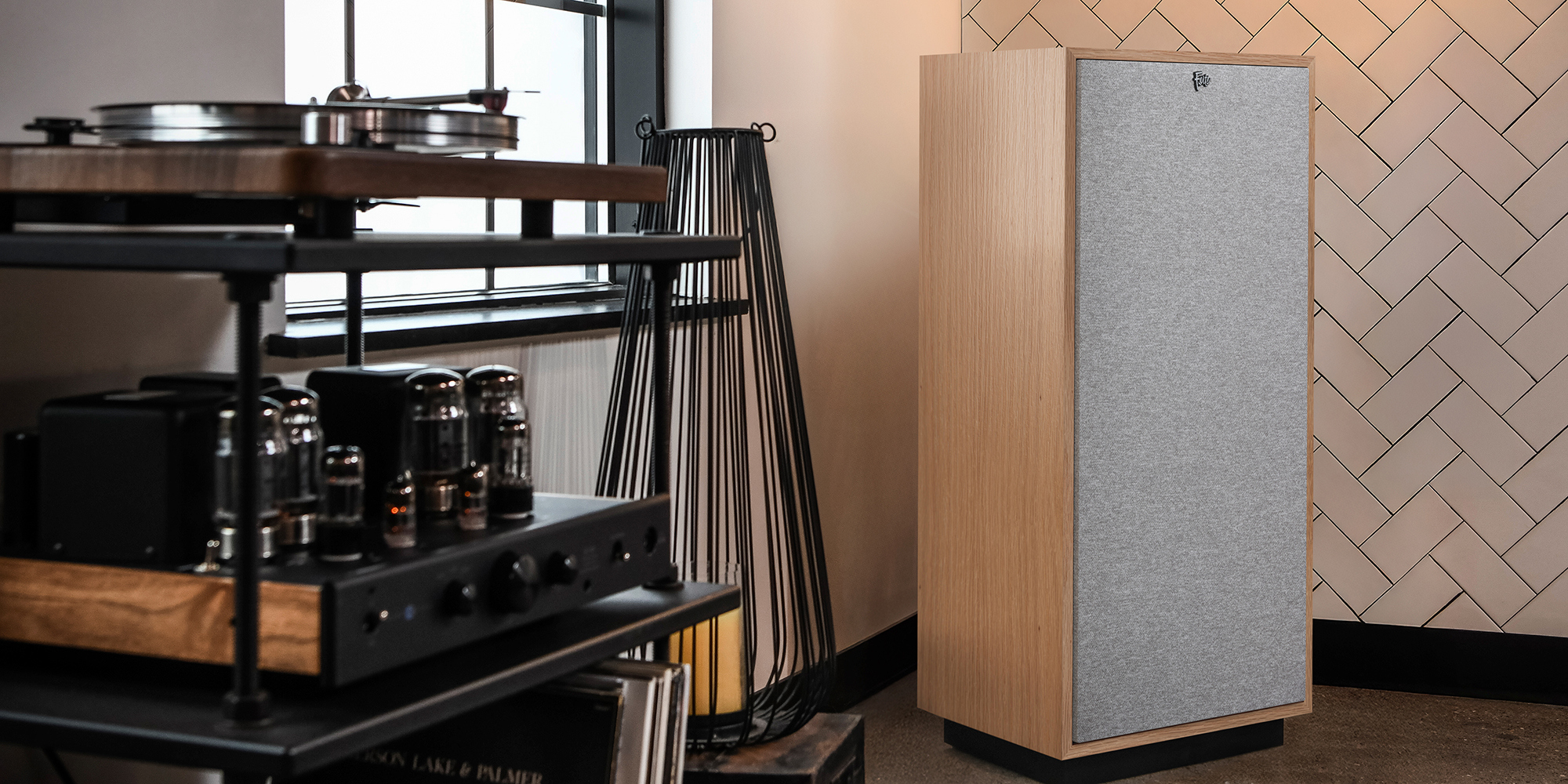 Klipsch Heresy IV in Red Oak finish in hi-fi listening room with white chevron tile wall